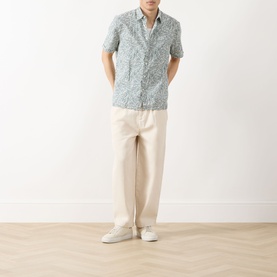 Model wearing Barbour Derham Patch Pocket Printed Shirt in Dusty Slate, styled with cream trousers and white trainers.