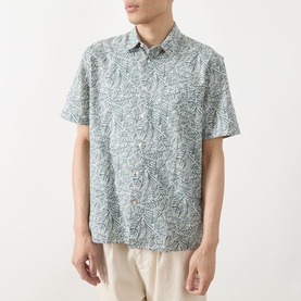 Model wearing Barbour Derham Patch Pocket Printed Shirt in Dusty Slate, all-over leaf print, short sleeves, styled with beige trousers