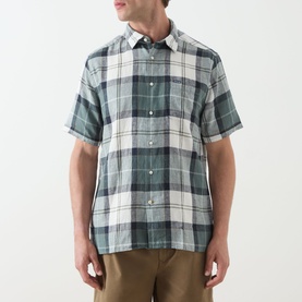 Model wearing Barbour casual shirt in Meadow Brook Tartan, green and cream check, short sleeves, button-down collar, styled with tan trousers