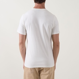 Model wearing Barbour Crew Neck T in Whisper White, shown from the back, styled with stone chino trousers.