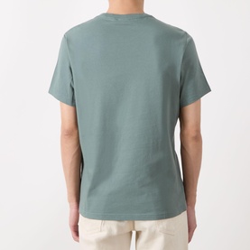 Model wearing Barbour Brayworth Graphic Logo T-Shirt in Vintage Teal, rear view, crew neck, short sleeves, straight hem, paired with cream trousers