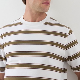 Model wearing Barbour white crew neck T-shirt with khaki and navy horizontal stripes, close-up of chest and neckline.