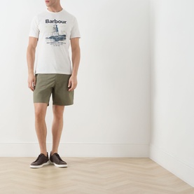 Model wearing Barbour Harbourside Graphic T-Shirt in Whisper White with khaki shorts and dark brown shoes.