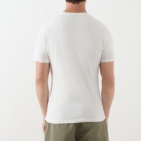 Model wearing Barbour Harbourside Graphic T-Shirt in Whisper White, rear view, crew neck, short sleeves, paired with khaki trousers