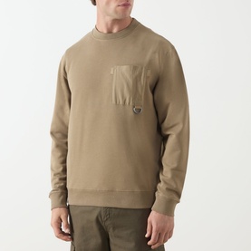 Model wearing Barbour clay cotton crew neck sweatshirt with tonal chest pocket and small logo badge, styled with khaki trousers