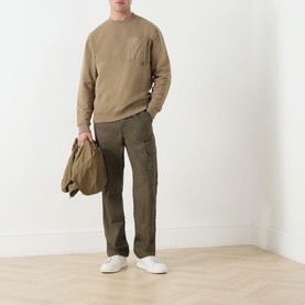 Model wearing Barbour Clay cotton crew neck sweatshirt with khaki cargo trousers and white trainers, carrying a canvas tote bag.