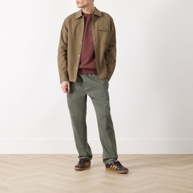 Model wearing Barbour Ivergill Patch Pocket Sweatshirt in Burnt Pepper, styled with tan overshirt, khaki trousers and navy trainers.