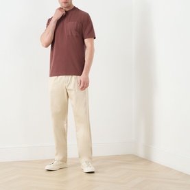 Model wearing Barbour Ivergill Patch Pocket T-Shirt in Burnt Pepper with cream trousers and white trainers.