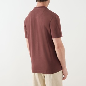 Model wearing Barbour Ivergill Patch Pocket T-Shirt in Burnt Pepper, back view, crew neck, short sleeves, styled with beige trousers.