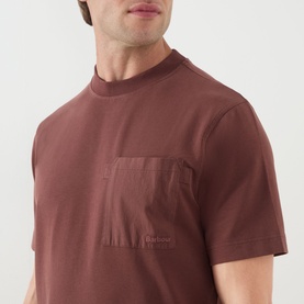 Model wearing Barbour Ivergill Patch Pocket T-Shirt in Burnt Pepper, showing contrast fabric chest pocket and embroidered logo detail.