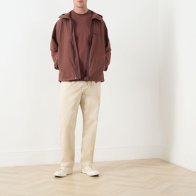 Model wearing Barbour Ivergill Patch Pocket T-Shirt in Burnt Pepper, styled with brown zip jacket and cream trousers.