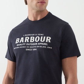 Model wearing Barbour Crew Neck T in Dark Navy with large white heritage logo graphic print to chest.