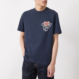 Model wearing Barbour Camping Trip T-Shirt in Navy, featuring Running Heart chest motif, crew neck, short sleeves, styled with dark denim jeans.