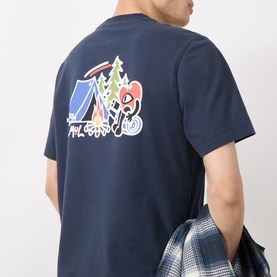 Model wearing Barbour Camping Trip T-Shirt in Navy, rear view showing Camping Trip graphic print with tent, trees and Running Heart motif.