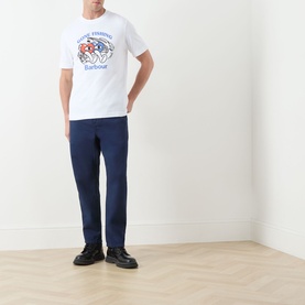 Model wearing Barbour white crew neck T-shirt with chest graphic print, styled with navy trousers and black shoes.