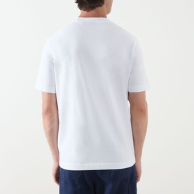 Model wearing Barbour Crew Neck T in white, rear view, styled with dark navy trousers.