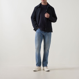 Model wearing Barbour Moonwell Graphic Logo T-Shirt in Dark Navy, styled with a navy jacket and light blue jeans.