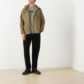 Model wearing khaki hooded zip-up jacket with grey logo sweatshirt, black trousers and black shoes