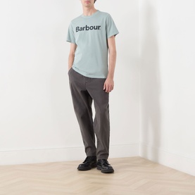 Model wearing Barbour Washington Overdyed Logo T-Shirt in Dusty Slate with dark grey trousers and black shoes.