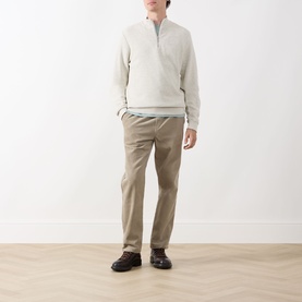 Model wearing Barbour Raven Logo Half-Zip Sweater in Ecru Marl, styled with beige chinos and dark brown boots.