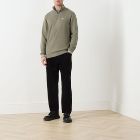 Model wearing Barbour Rosford Logo Half-Zip Sweatshirt in Dusty Olive with black cord trousers and black chunky shoes.