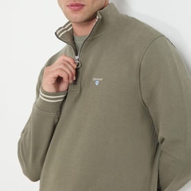 Model wearing Barbour Rosford Logo Half-Zip Sweatshirt in Dusty Olive, showing embroidered chest logo and tipped funnel neck detail.