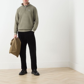 Model wearing Barbour Rosford Logo Half-Zip Sweatshirt in Dusty Olive with black trousers and boots, carrying a tan tote bag.