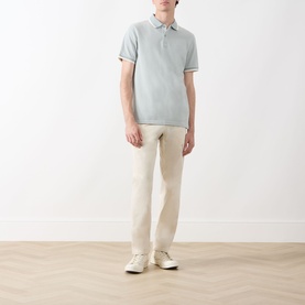 Model wearing Barbour Barnard Logo Polo Shirt in Dusty Slate with cream trousers and white trainers