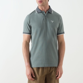 Model wearing Barbour Vintage Teal polo shirt with white tipping on collar and cuffs, styled with khaki trousers.