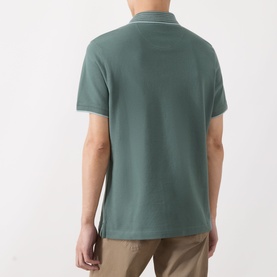Model wearing Barbour polo shirt in Vintage Teal, rear view, piqu&eacute; cotton with contrast tipped collar, styled with beige chinos.