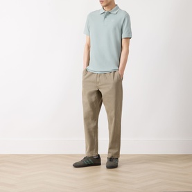 Model wearing Barbour polo in Dusty Slate, styled with beige chinos and dark grey loafers