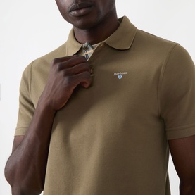 Model wearing Barbour polo shirt in Clay, 100% cotton piqu&eacute; with contrast tartan collar trim, close-up chest detail view.