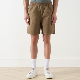 Model wearing Barbour clay cotton shorts with elasticated waist, styled with white socks and white trainers