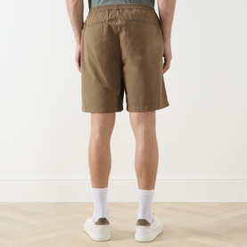 Model wearing Barbour clay cotton shorts, rear view, styled with white crew socks and white trainers