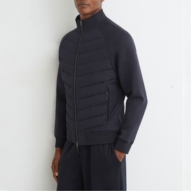 Model wearing Reiss blue quilted front zip-through jacket with funnel neck, styled with matching navy trousers