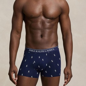 Model wearing Ralph Lauren Classic Stretch Trunk 3-Pack in navy AOP with all-over pony print and signature logo elastic waistband.