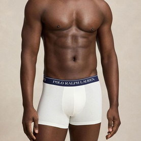 Model wearing Ralph Lauren Classic Stretch Trunk in paper white with navy logo elastic waistband, cropped torso view