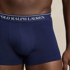 Model wearing Ralph Lauren Classic Stretch Trunk in navy, showing logo elastic waistband and contoured pouch. Part of a 3-pack set.