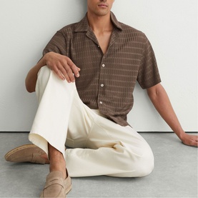 Model wearing Reiss taupe brown short-sleeve striped camp collar shirt, styled with cream wide-leg trousers and tan loafers