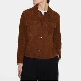 Model wearing tan suede cropped jacket with chest pockets, button front, and shirt collar, styled with black trousers