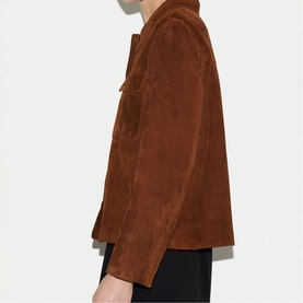 Model wearing tan brown suede jacket, side profile view, styled with black trousers