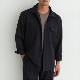 Model wearing Reiss blue overshirt with chest pockets and button front, styled with matching blue trousers