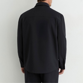 Model wearing Reiss blue long-sleeve shirt, rear view, styled with matching navy trousers.