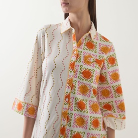 Model wearing Chelsea Peers Sunshine Tile Print Night Shirt in Sunshine Grid, showing orange and pink floral tile print with classic collar and