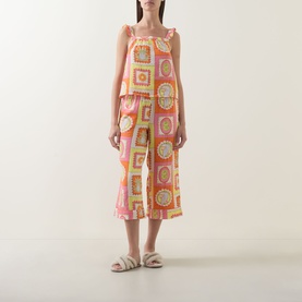 Model wearing Chelsea Peers Tropical Patchwork Print Cheesecloth Pyjama Set in pink grid print cami and cropped wide-leg trousers, styled with white