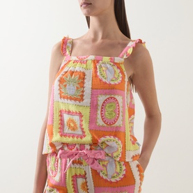 Model wearing Chelsea Peers Tropical Patchwork Print Cheesecloth Pyjama Set, orange patchwork cami top with frill straps, styled with matching shorts.