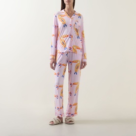 Model wearing Chelsea Peers Toucan Print Long Pyjama Set in Multicolour Dot Toucan, pink two-piece with long sleeves and straight-leg trousers