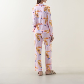 Model wearing Chelsea Peers Toucan Print Long Pyjama Set in Multicolour Dot Toucan, showing back view of long-sleeve top and straight-leg trousers