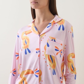 Model wearing Chelsea Peers Toucan Print Long Pyjama Set in Multicolour Dot Toucan, showing revere collar, long sleeves and front button fastening.