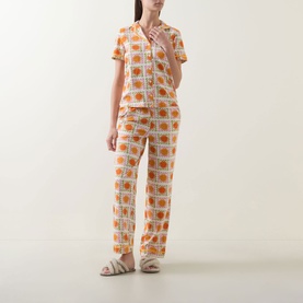 Model wearing Chelsea Peers Sunshine Tile Print Long Pyjama Set in Sunshine Grid, short-sleeve shirt and straight-leg trousers with all-over tile